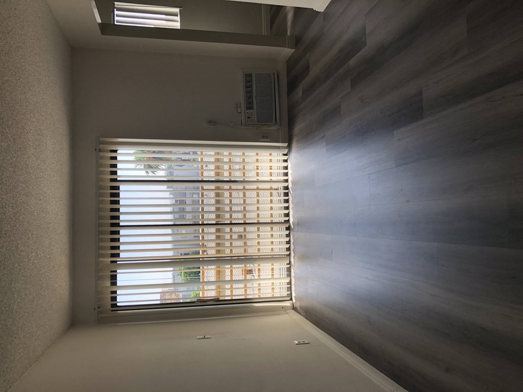 a window with blinds in a room with a window sill
