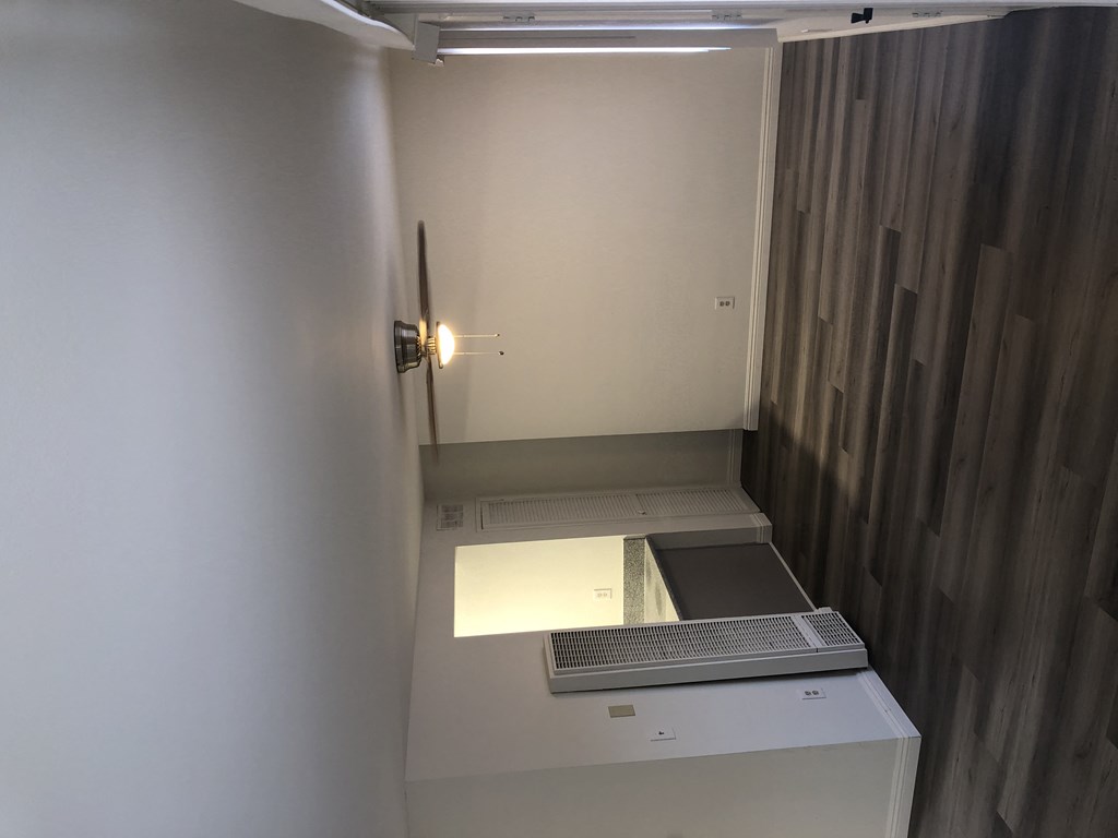 an empty room with a desk with a computer