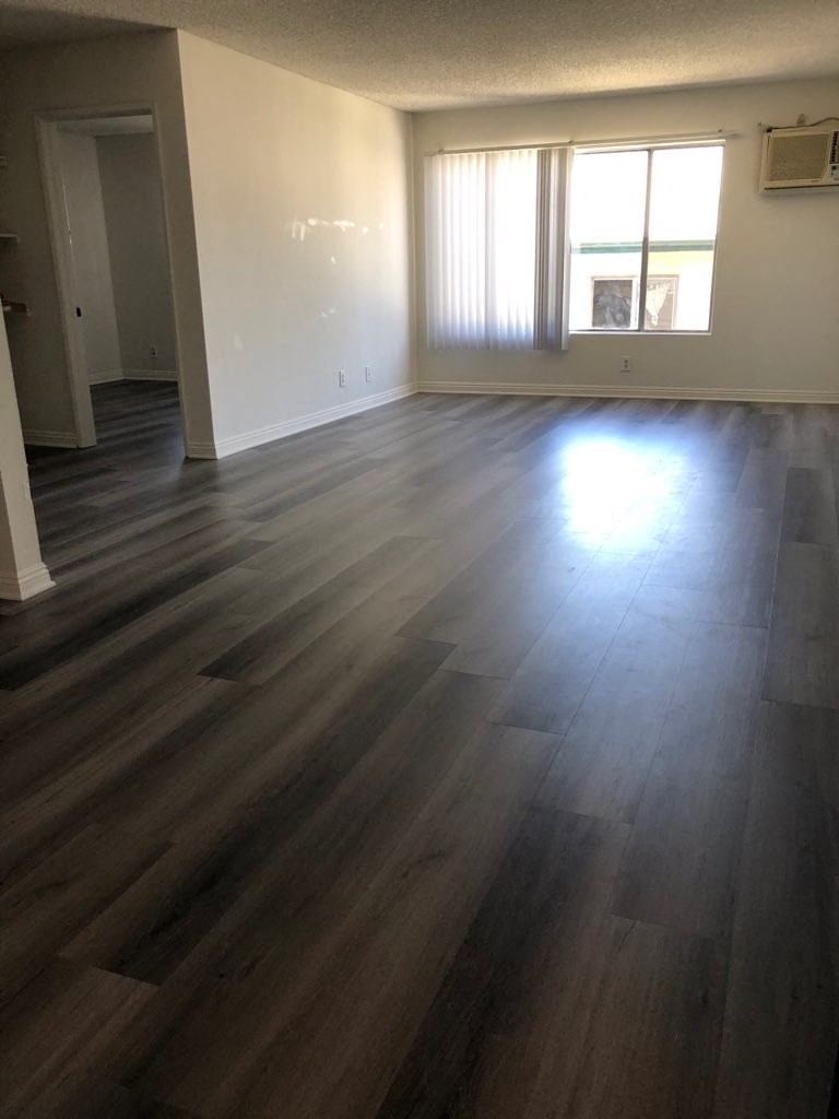 an empty living room with hard wood floors