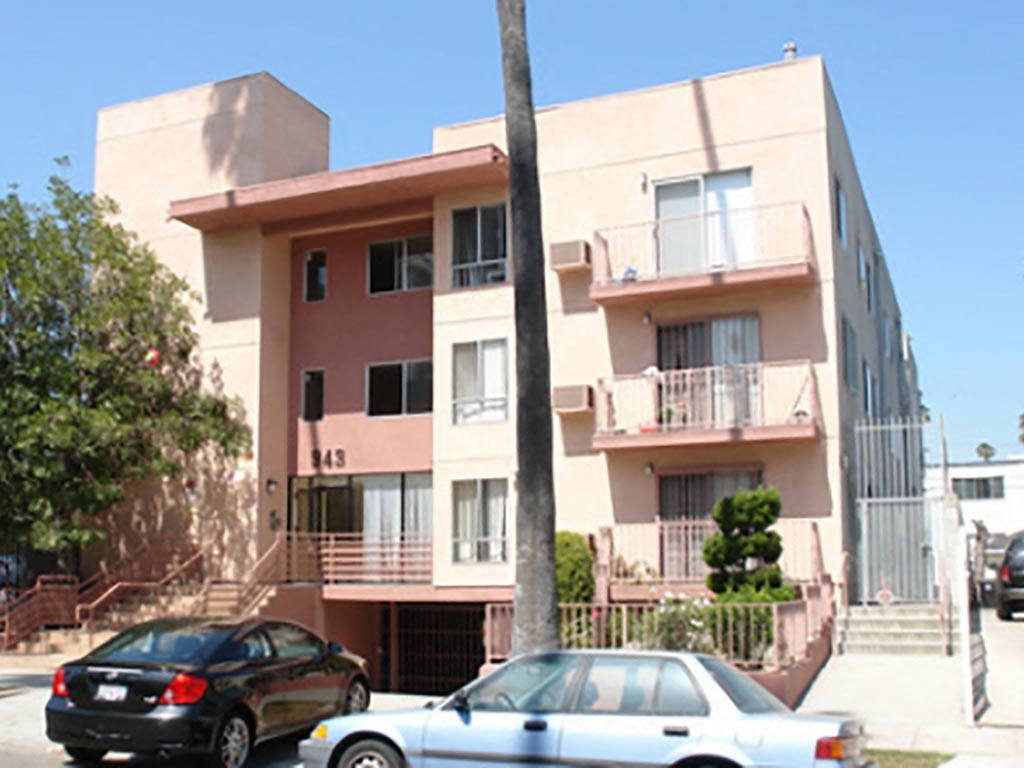 an apartment building with cars parked in front of it