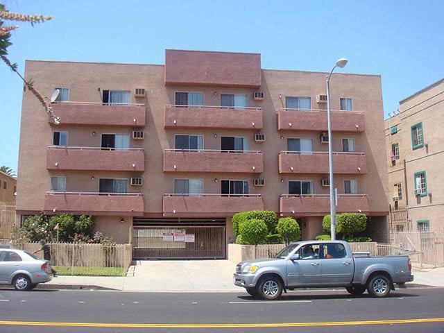 a truck parked in front of an apartment building