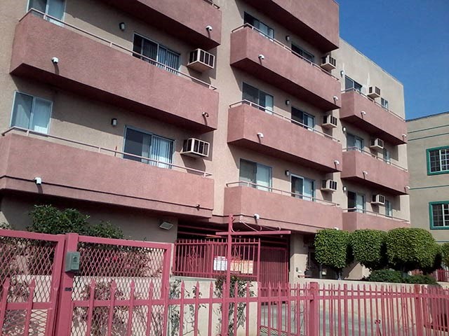 a pink fence in front of an apartment building