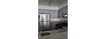 A kitchen with a stainless steel refrigerator and a stove top oven.