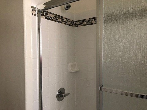 a bathroom with a shower with a glass door