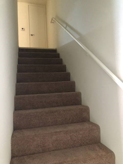 a flight of stairs with a hand rail and a door