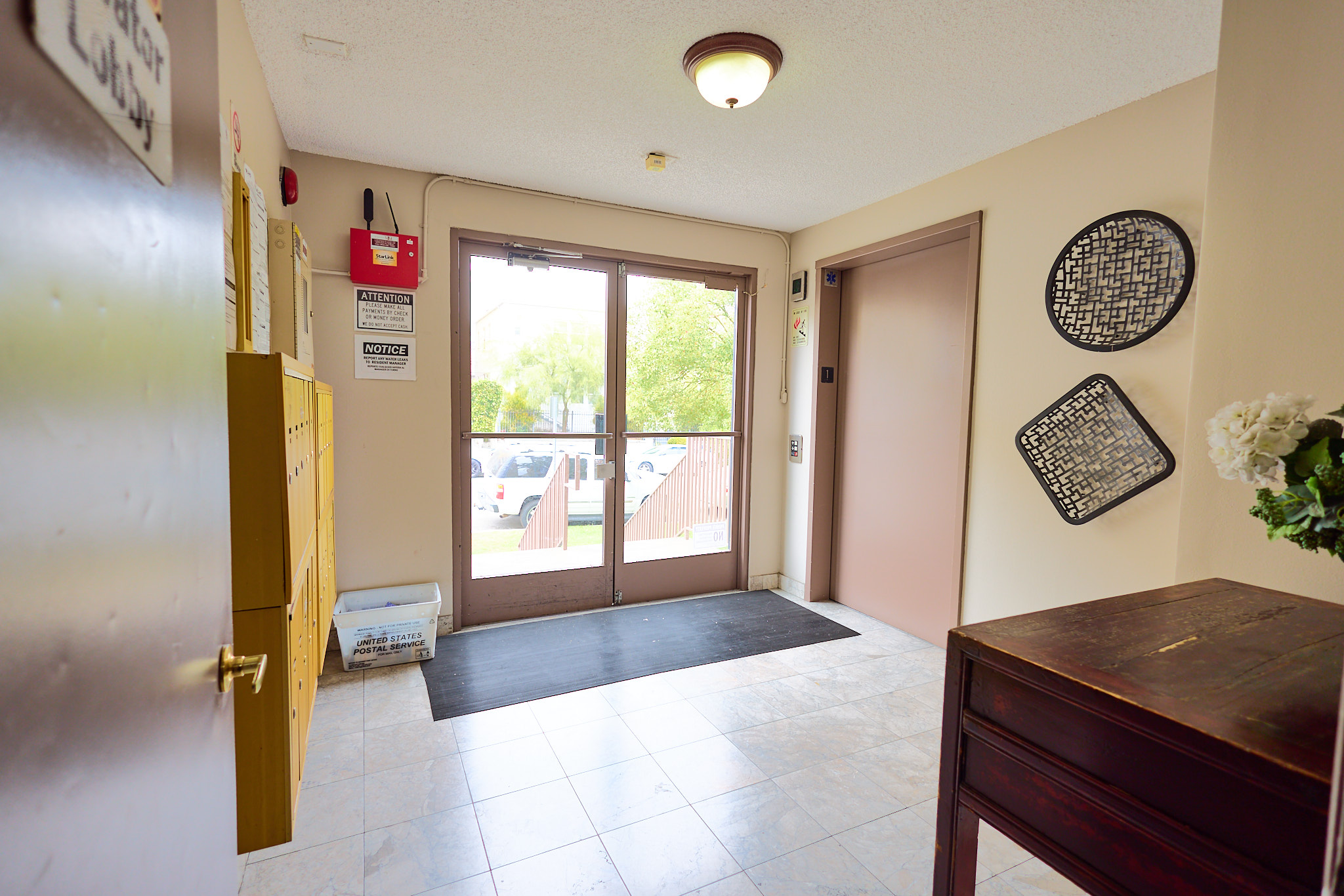 A room with a brown door and a black and white picture on the wall.