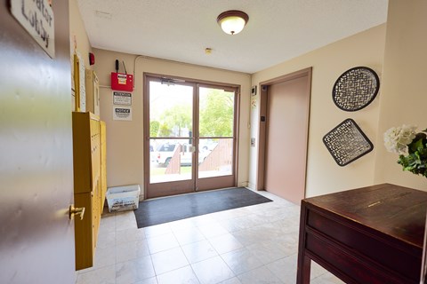 A room with a brown door and a black and white picture on the wall.