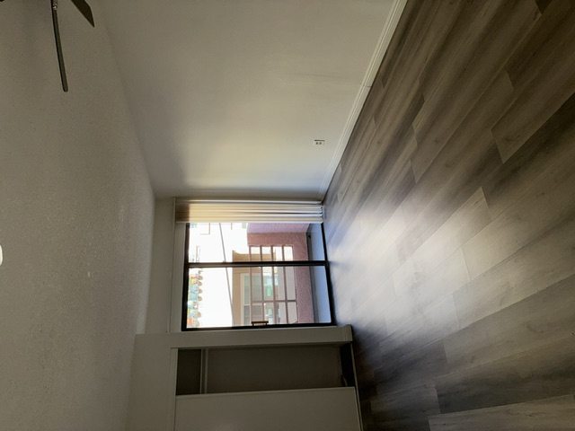 A room with a window and a ceiling fan.