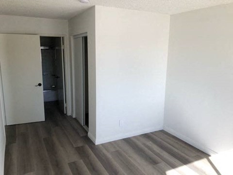 a empty room with white walls and wood floors