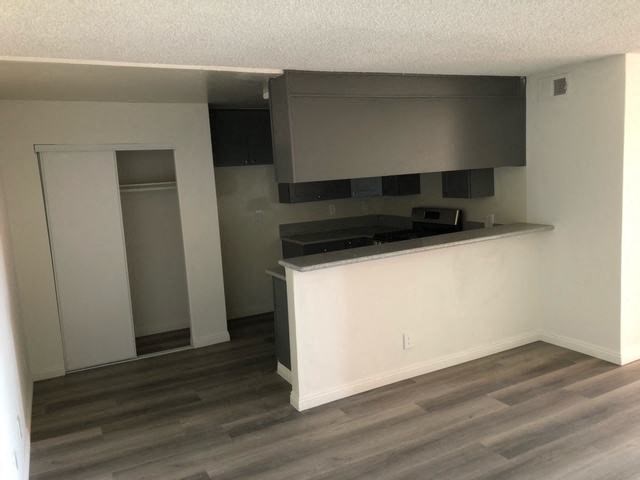 an empty kitchen with a counter top and a microwave