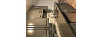A kitchen with stainless steel appliances and a tile backsplash.