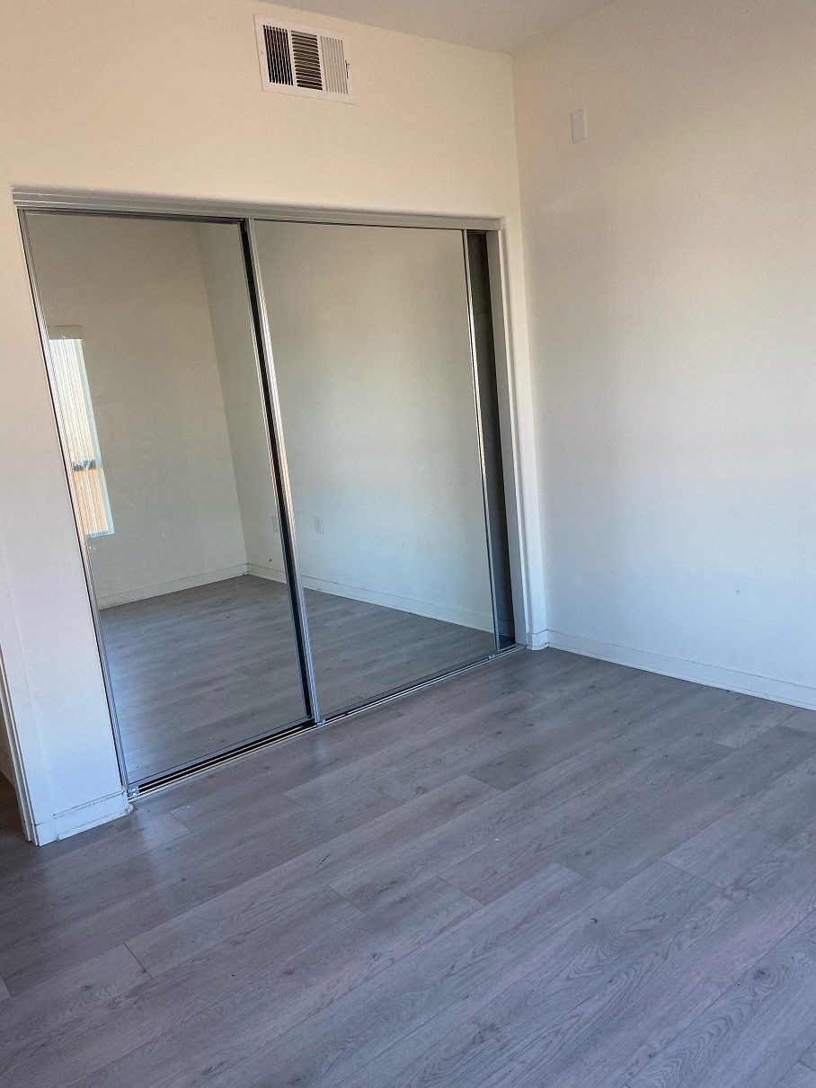 a room with a floor to ceiling mirror and wooden floors