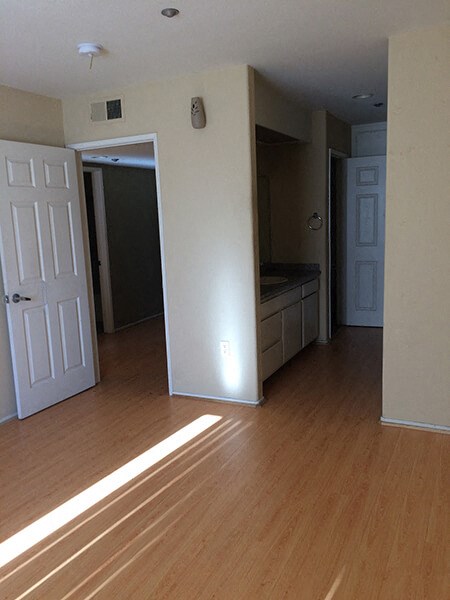 a living room and a kitchen with wood floors