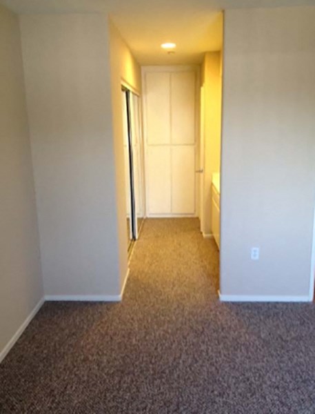 a hallway with a door to a bedroom and a closet