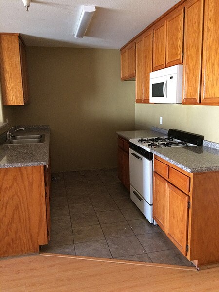 a kitchen with a stove and a sink and a microwave