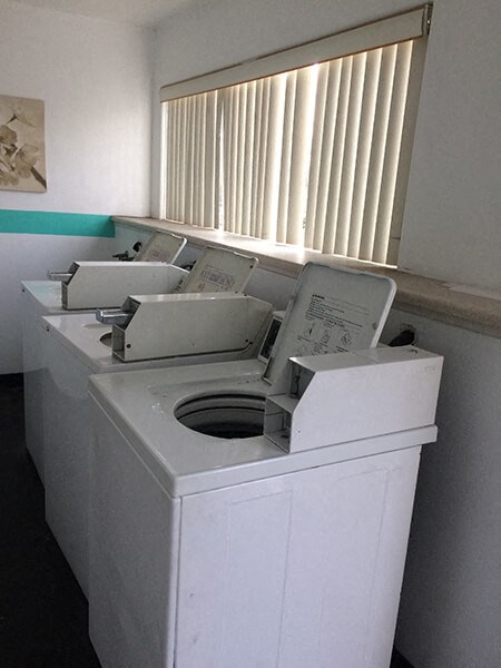 a white washing machine in a room with a window