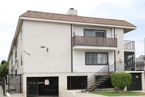 a white house with a balcony and a driveway