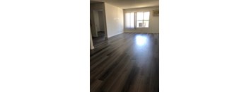A room with wooden flooring and a window.