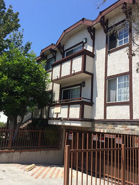 an apartment building with a fence in front of it