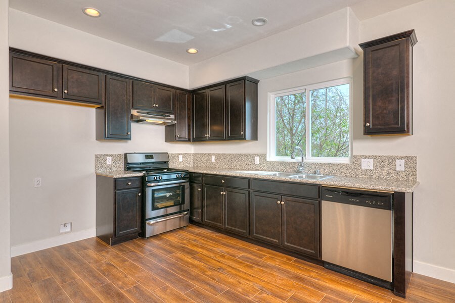 a kitchen with dark wood cabinets and a window
