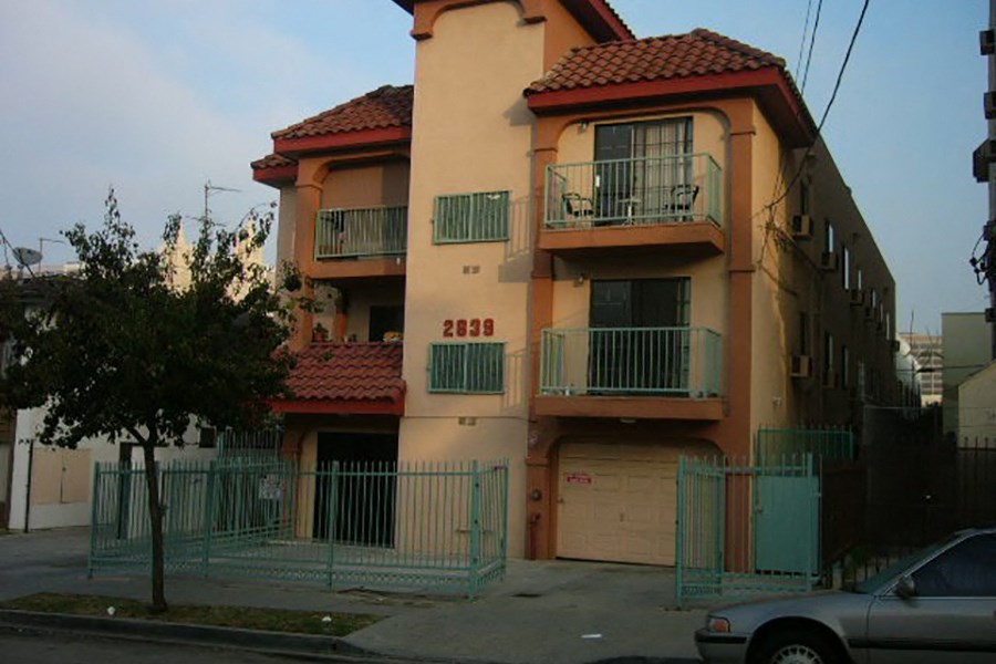 an apartment building with a car parked in front of it
