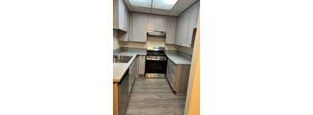 A kitchen with a stove top oven and a sink.