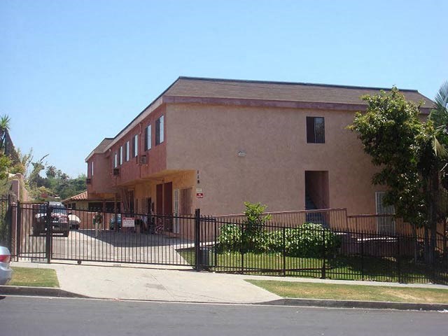 a brown building with a fence and a gate