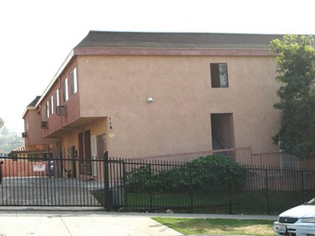 a large building with a fence and a car parked in front of it