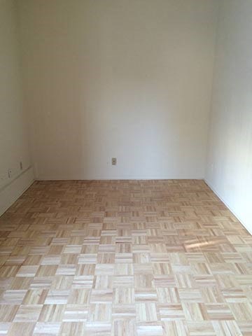 a room with a wooden floor and a white wall