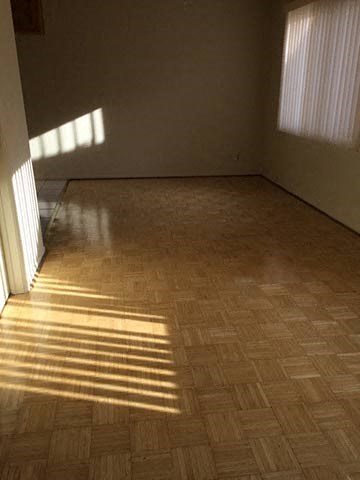 a living room with a wooden floor and a window