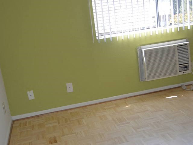 a room with green walls and a window and a radiator