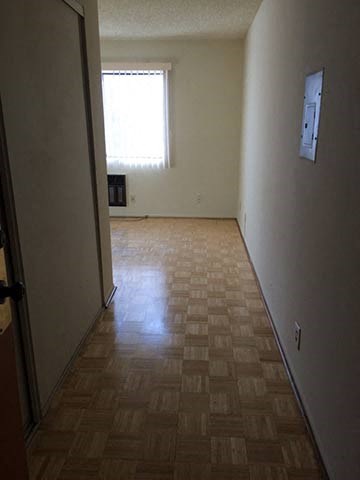 a room with a wooden floor and a window