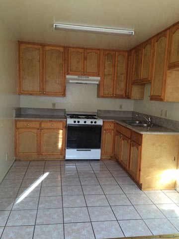 a kitchen with wooden cabinets and a white stove