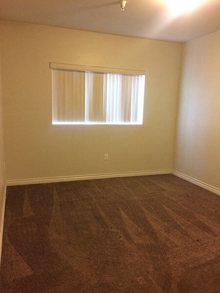 a empty room with a window and a wooden floor
