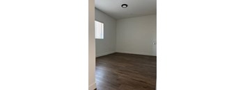 A room with wooden flooring and white walls.