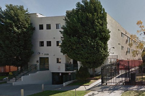 the exterior of a white building with trees in front of it