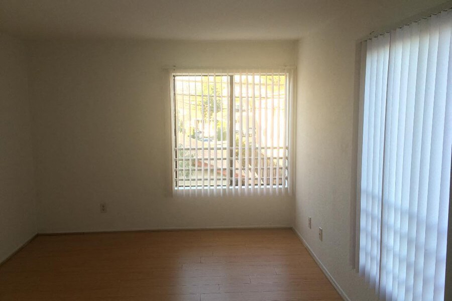 an empty living room with a window and