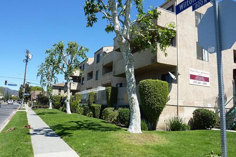 an apartment building with trees in front of it