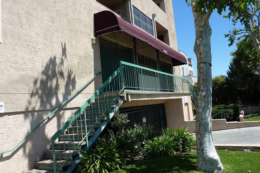 an apartment building with stairs  and a tree