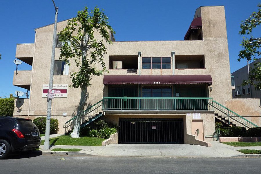an apartment building with a car parked in front of it