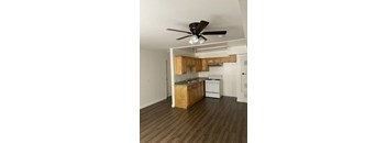 A kitchen with wooden cabinets and a ceiling fan.