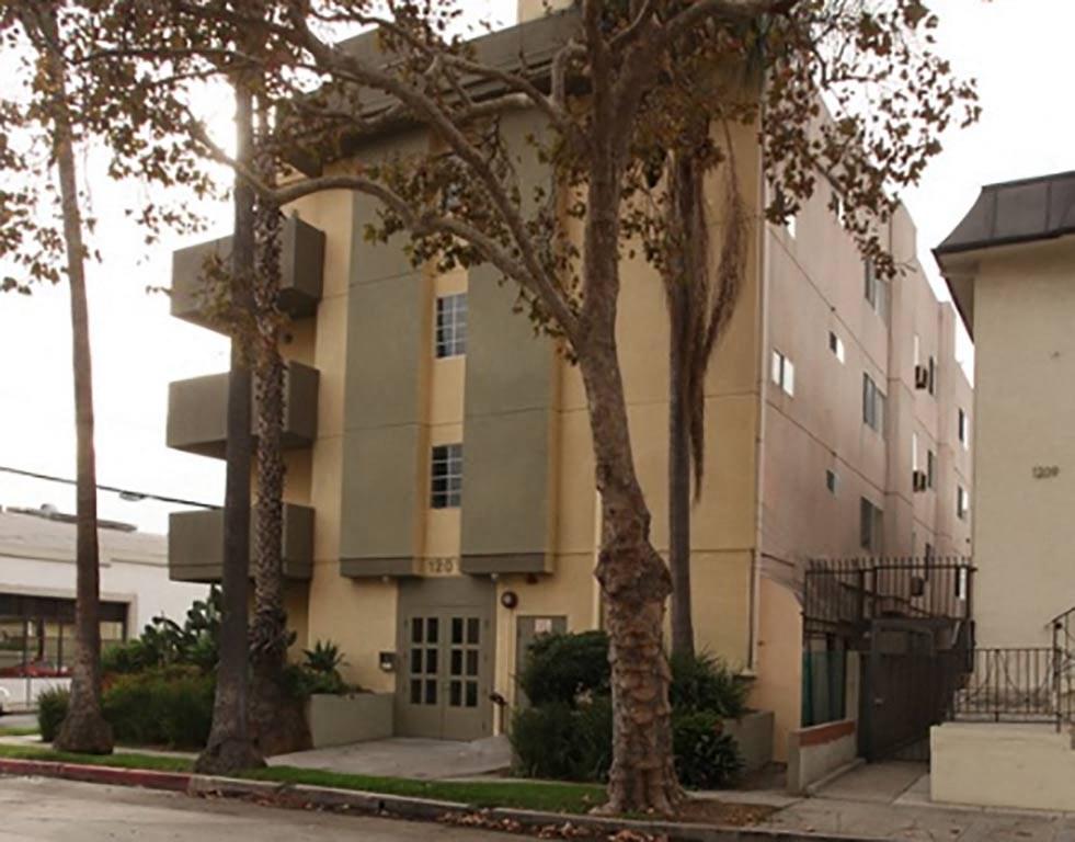 an apartment building with trees in front of it