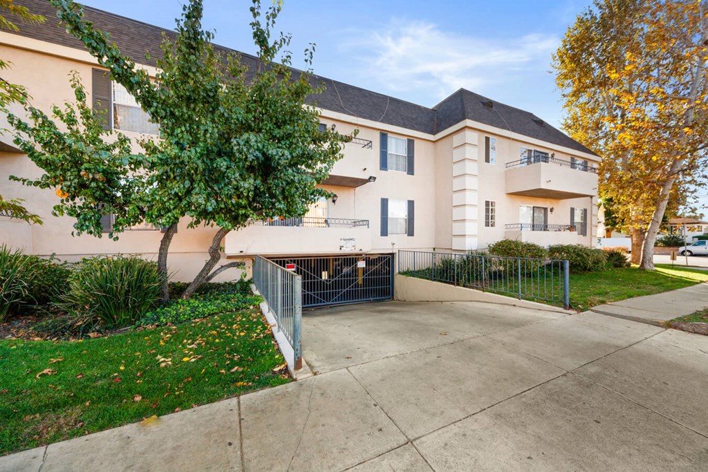 the sidewalk in front of an apartment building with a driveway