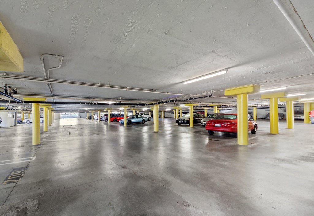 a parking garage filled with cars and yellow pillars