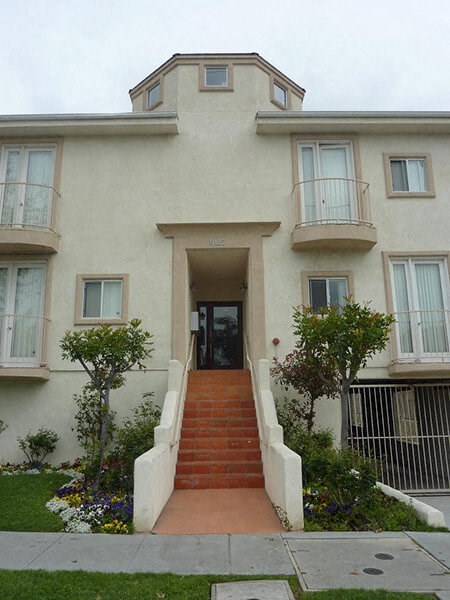 a white house with a red sidewalk in front of it