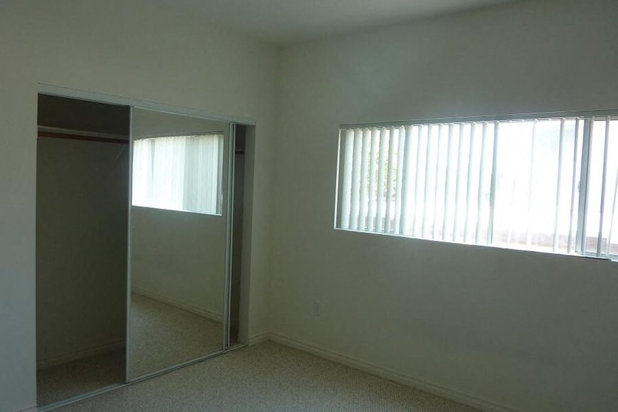 an empty room with a window and a mirror
