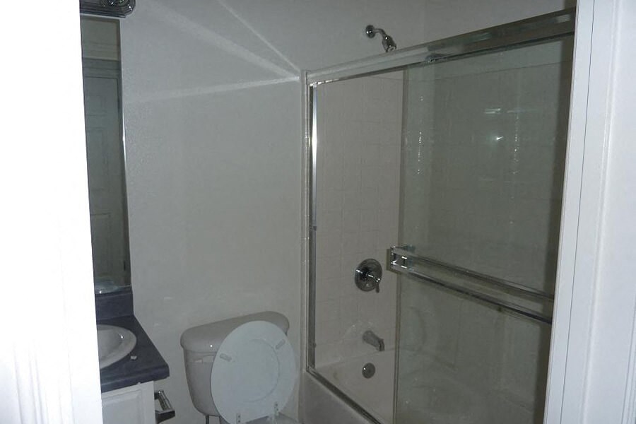 a white bathroom with a shower and a toilet