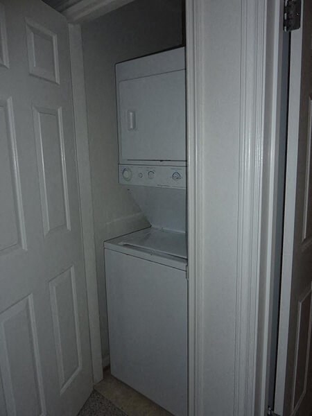 a white washer and dryer in a white closet