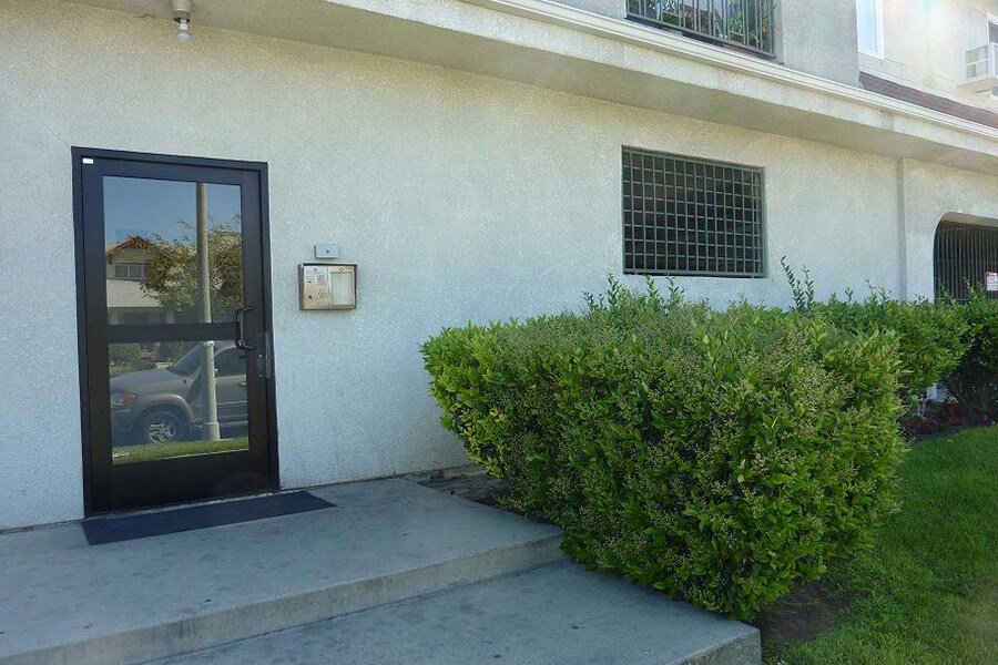 a building with a glass door and a sidewalk