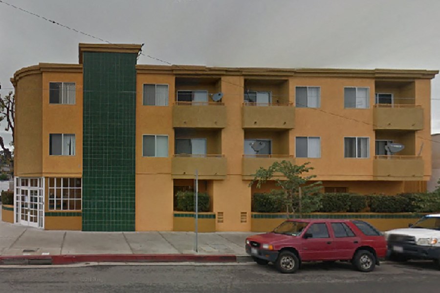 a red car parked in front of an apartment building